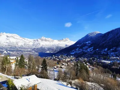 a town in the snow with mountains in the background at Le Montagnard in Saint-Gervais-les-Bains