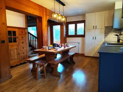 a kitchen with a wooden table in the middle of a room at Le Montagnard in Saint-Gervais-les-Bains