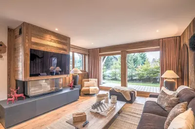 a living room with a couch and a tv at Appartement Reflet des Cimes - Welkeys in Megève