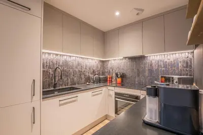 a kitchen with white cabinets and a coffee maker at Appartement Reflet des Cimes - Welkeys in Megève