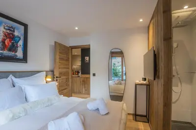 a bedroom with a large bed and a television at Appartement Reflet des Cimes - Welkeys in Megève