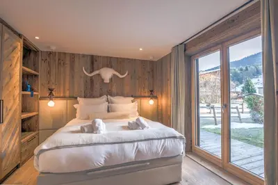a bedroom with a large bed with two dogs on it at Appartement Reflet des Cimes - Welkeys in Megève