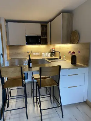a kitchen with a counter with chairs and a sink at MontBlanc11 in Chamonix-Mont-Blanc