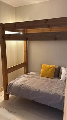 a bedroom with a wooden bunk bed with a yellow pillow at MontBlanc11 in Chamonix-Mont-Blanc