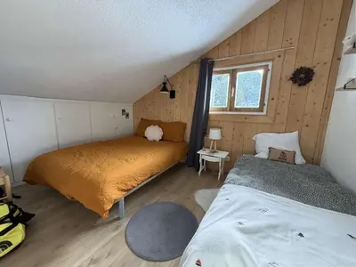 a bedroom with two beds and a window at Studio mezzanine à 300m des pistes, balcon sud, jusqu'à 4 personnes - FR-1-572-342 in Arâches-la-Frasse
