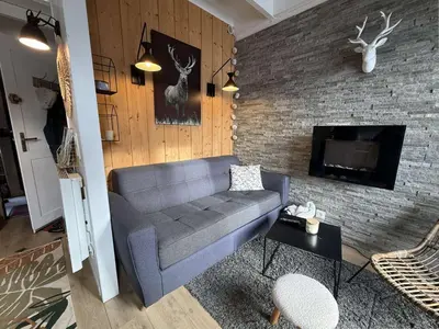 a living room with a couch and a brick wall at Studio mezzanine à 300m des pistes, balcon sud, jusqu'à 4 personnes - FR-1-572-342 in Arâches-la-Frasse