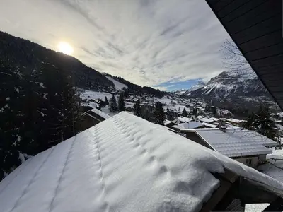 a snow covered roof of a house with a mountain at Studio mezzanine à 300m des pistes, balcon sud, jusqu'à 4 personnes - FR-1-572-342 in Arâches-la-Frasse