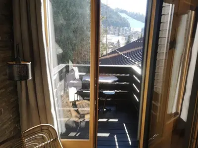 an open door to a balcony with a table and chairs at Studio mezzanine à 300m des pistes, balcon sud, jusqu'à 4 personnes - FR-1-572-342 in Arâches-la-Frasse