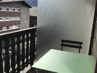 a white table on a balcony with a chair at Appartement rénové 1 chambre avec balcon, parking et wifi centre station - FR-1-836-62 in Arâches-la-Frasse