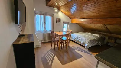 a bedroom with a bed and a table with a desk at Mini cozy au MontBlanc in Sallanches