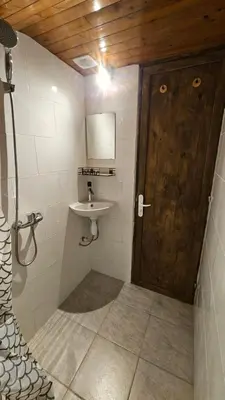 a bathroom with a wooden door and a sink at Mini cozy au MontBlanc in Sallanches