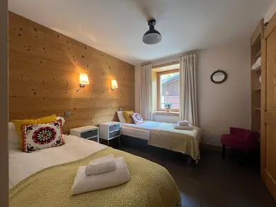 a hotel room with two beds and a window at Chamonix Trailside Town Apartments in Chamonix-Mont-Blanc