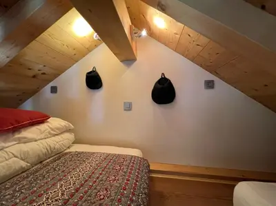 a bedroom with a bed and two black objects on the wall at Chamonix Trailside Town Apartments in Chamonix-Mont-Blanc