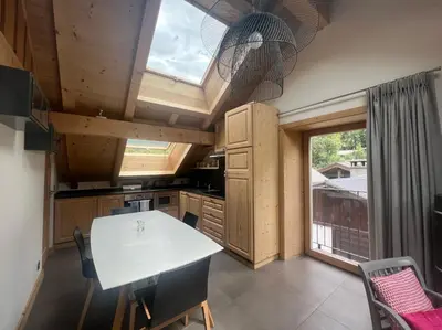 a kitchen with a white table and a large window at Chamonix Trailside Town Apartments in Chamonix-Mont-Blanc