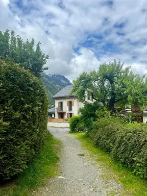 a dirt road leading to a house with a tree at Chamonix Trailside Town Apartments in Chamonix-Mont-Blanc