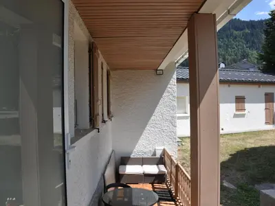 a balcony with a table and chairs on a house at Appartement rénové 2 chambres, centre station, 300m des pistes, 6 pers, WiFi - FR-1-836-63 in Arâches-la-Frasse