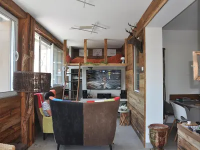 a living room with a person playing a video game at Appartement rénové 2 chambres, centre station, 300m des pistes, 6 pers, WiFi - FR-1-836-63 in Arâches-la-Frasse