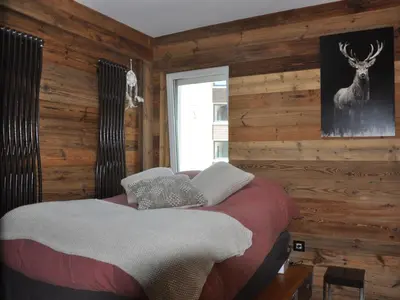a bedroom with a bed in a room with wooden walls at Appartement rénové 2 chambres, centre station, 300m des pistes, 6 pers, WiFi - FR-1-836-63 in Arâches-la-Frasse
