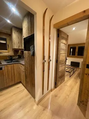 a kitchen with wooden cabinets and a sliding door at Charmant appartement en plein centre in Megève