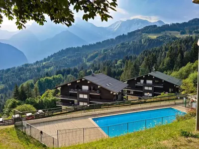 a resort with a swimming pool in the mountains at appartement proche ski et randonnées, vue montagne in Saint-Gervais-les-Bains