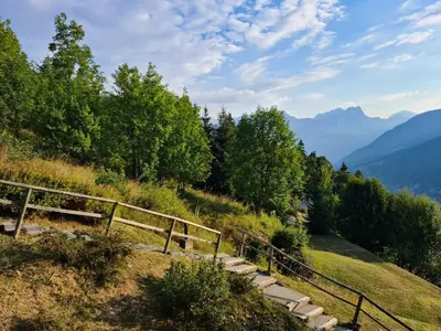 a set of stairs on a hill with trees and mountains at appartement proche ski et randonnées, vue montagne in Saint-Gervais-les-Bains