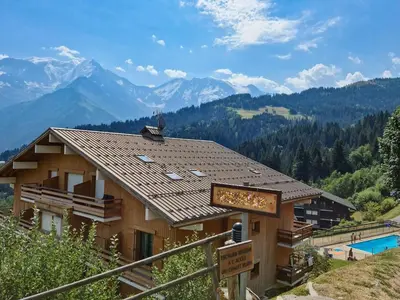 a sign in front of a building with mountains in the background at appartement proche ski et randonnées, vue montagne in Saint-Gervais-les-Bains