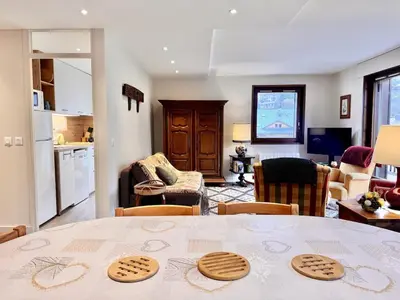 a kitchen and living room with a table with cookies on it at Le Saphir Montagne & Ski in Saint-Gervais-les-Bains
