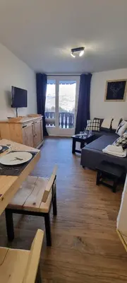 a living room with a couch and a bed and a table at Les Arcades N105 ST4 in Morillon