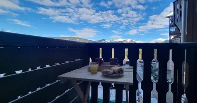 a table on a balcony with a view of the mountains at Les Arcades N105 ST4 in Morillon