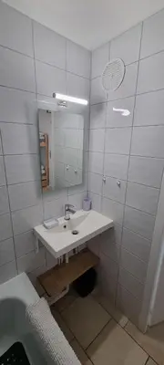 a white bathroom with a sink and a mirror at Les Arcades N105 ST4 in Morillon