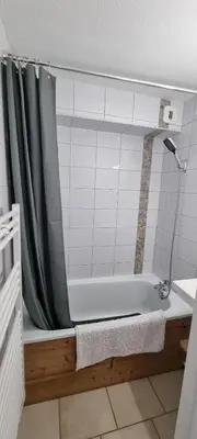 a bathroom with a bath tub with a shower curtain at Les Arcades N105 ST4 in Morillon