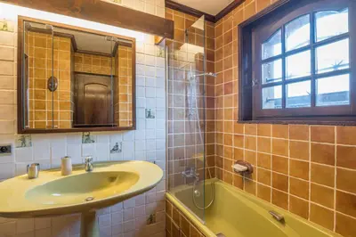 a bathroom with a sink and a tub and a window at Demi-chalet Le pré du loup - Welkeys in Megève
