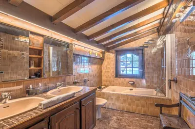 a bathroom with two sinks and a tub and a toilet at Demi-chalet Le pré du loup - Welkeys in Megève