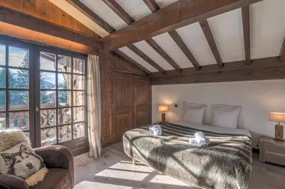 a bedroom with a bed and a large window at Demi-chalet Le pré du loup - Welkeys in Megève