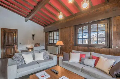 a living room with two couches and a table at Demi-chalet Le pré du loup - Welkeys in Megève