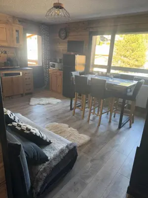 a kitchen and dining room with a table and chairs at Studio COCOONING LE CARIBOU in Les Carroz d'Araches