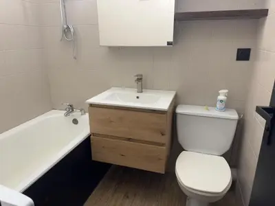 a bathroom with a toilet and a sink and a tub at Studio COCOONING LE CARIBOU in Les Carroz d'Araches