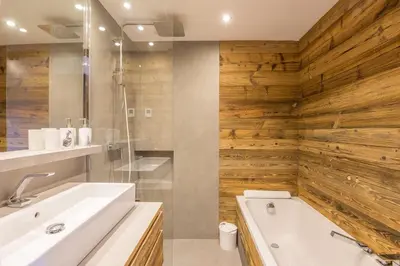 a bathroom with a white tub and wooden walls at Appartement Thoret - 3 étoiles - Welkeys in Megève