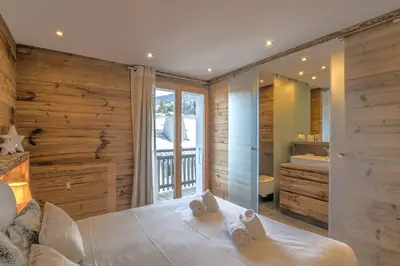 a bedroom with a large bed and a bathroom at Appartement Thoret - 3 étoiles - Welkeys in Megève