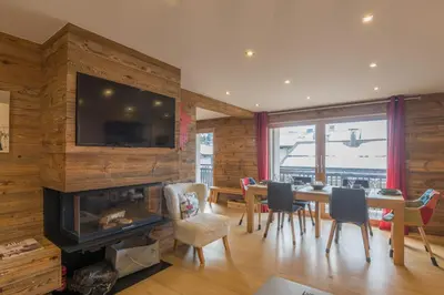 a dining room with a fireplace and a table and chairs at Appartement Thoret - 3 étoiles - Welkeys in Megève
