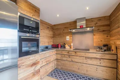 a kitchen with wood paneled walls and an oven at Appartement Thoret - 3 étoiles - Welkeys in Megève