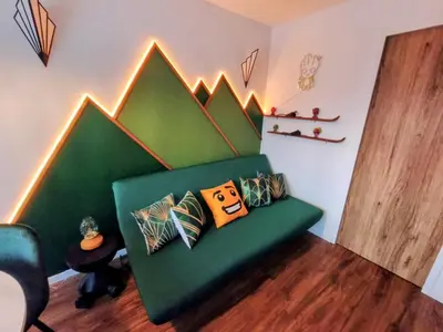 a green couch with pillows in a room at Gamebox in Carroz in Les Carroz d'Araches