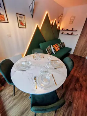 a dining room with a white table and green chairs at Gamebox in Carroz in Les Carroz d'Araches