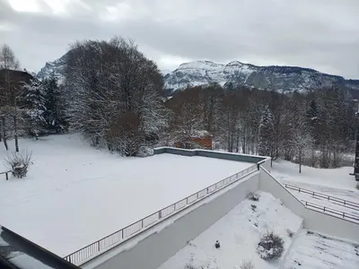 a snow covered roof of a house with mountains in the background at Gamebox in Carroz in Les Carroz d'Araches