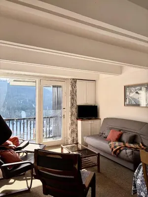 a living room with a couch and a table and chairs at Résidence Aldebaran - Appartement spacieux · Départ et retour ski aux pieds · Balcon · Casier à ski · WIFI gratuit MAE-1963 in Magland