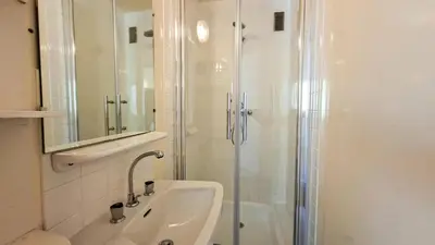 a white bathroom with a shower and a sink at Résidence Aldebaran - Appartement spacieux · Départ et retour ski aux pieds · Balcon · Casier à ski · WIFI gratuit MAE-1963 in Magland