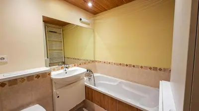 a dining room with a table and chairs and a clock at Résidence Aldebaran - Appartement spacieux · Départ et retour ski aux pieds · Balcon · Casier à ski · WIFI gratuit MAE-1963 in Magland