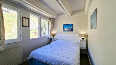a bedroom with a bed and two windows at Résidence Aldebaran - Appartement spacieux · Départ et retour ski aux pieds · Balcon · Casier à ski · WIFI gratuit MAE-1963 in Magland