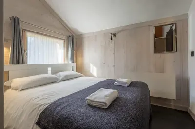 a bedroom with a large bed with two towels on it at Le Refuge in Chamonix-Mont-Blanc