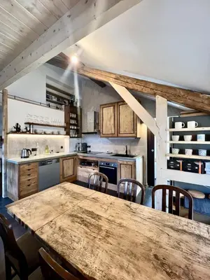 a large kitchen with a wooden table and chairs at Le Refuge in Chamonix-Mont-Blanc